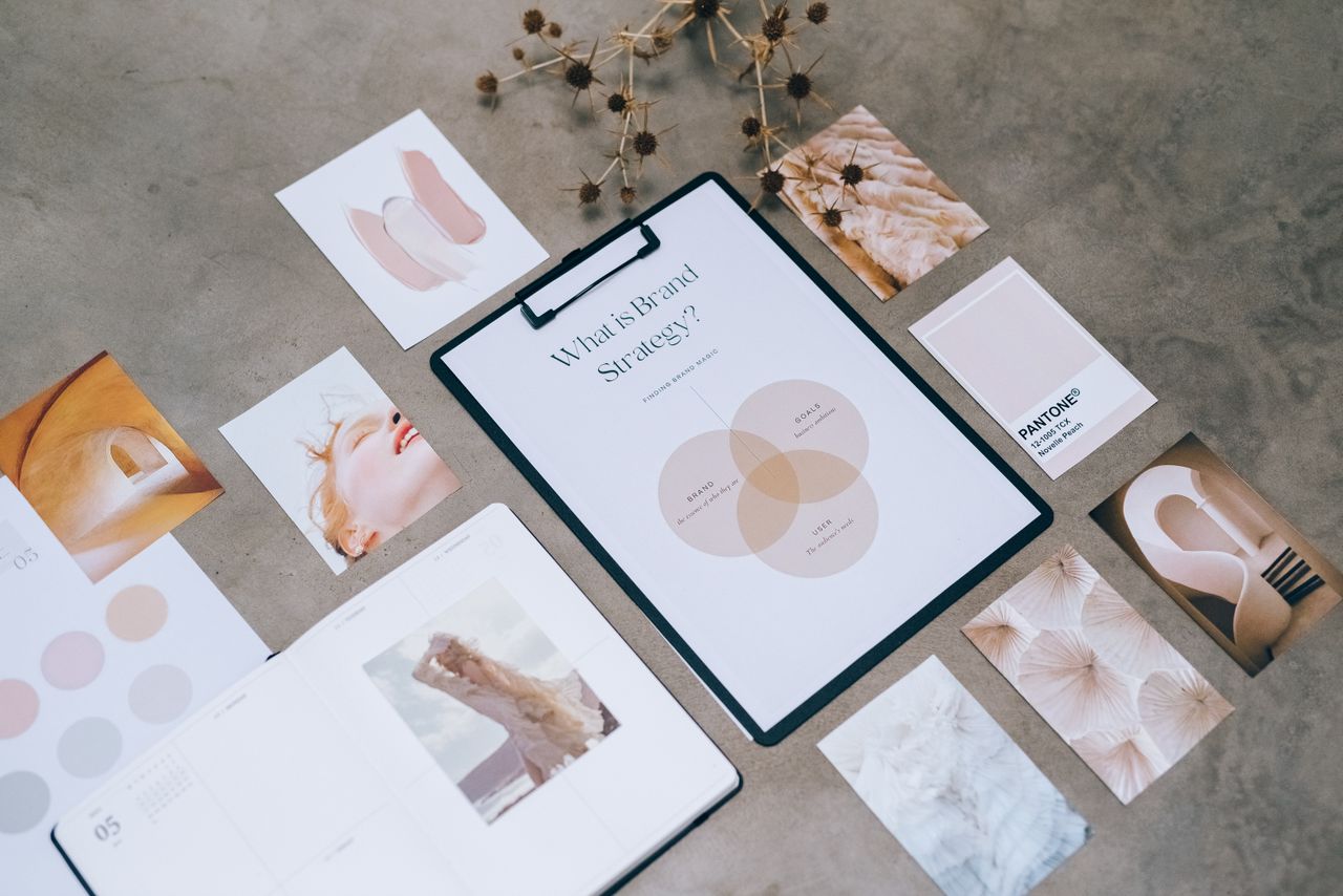 Flat lay of a minimalist brand strategy mood board arranged on a concrete surface.